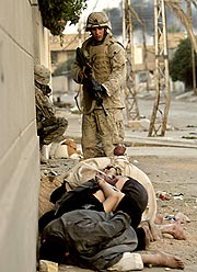 １１日、イラク中部ファルージャの中心部で、イラク人を拘束した米海兵隊員＝ＡＰ