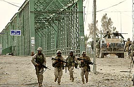 イラクのファルージャ西部で１４日、警戒しながら進む米海兵隊の兵士たち＝ＡＰ