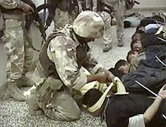イラク中部ファルージャの病院で８日、拘束したイラク人男性に目隠しをする突入部隊の隊員