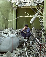 イラクのファルージャで空爆をうけ、壊れた建物に座るイラク人男性＝ＡＰ